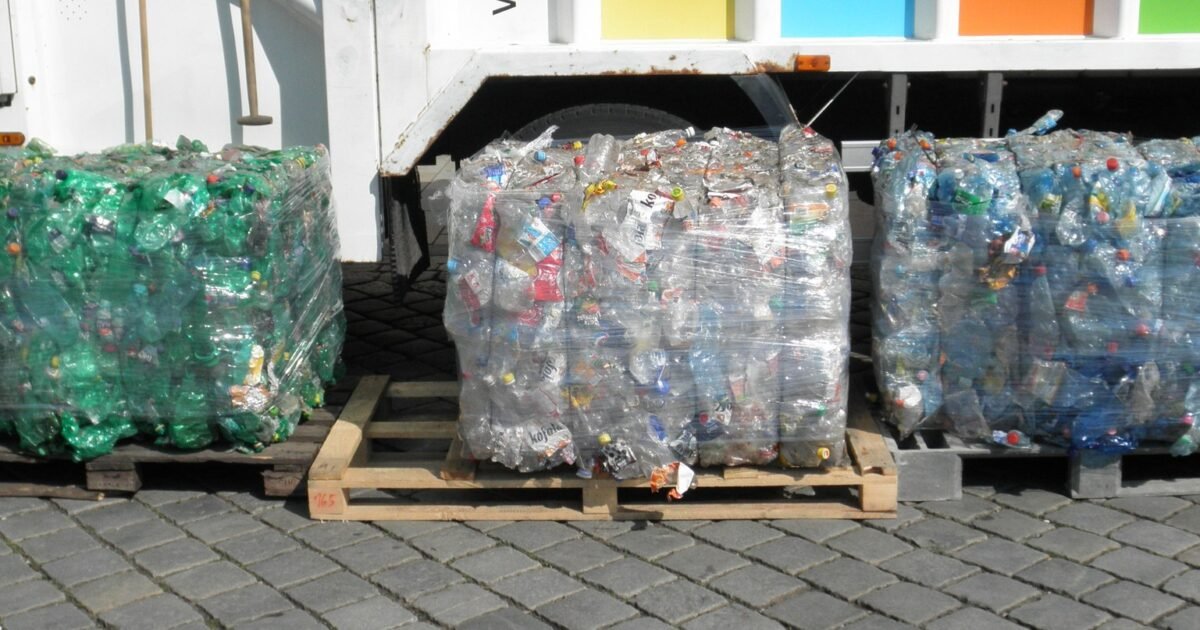Wide landscape view of compacted PET plastic bottle bales ready for recycling