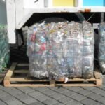 Wide landscape view of compacted PET plastic bottle bales ready for recycling