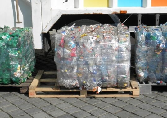 Wide landscape view of compacted PET plastic bottle bales ready for recycling
