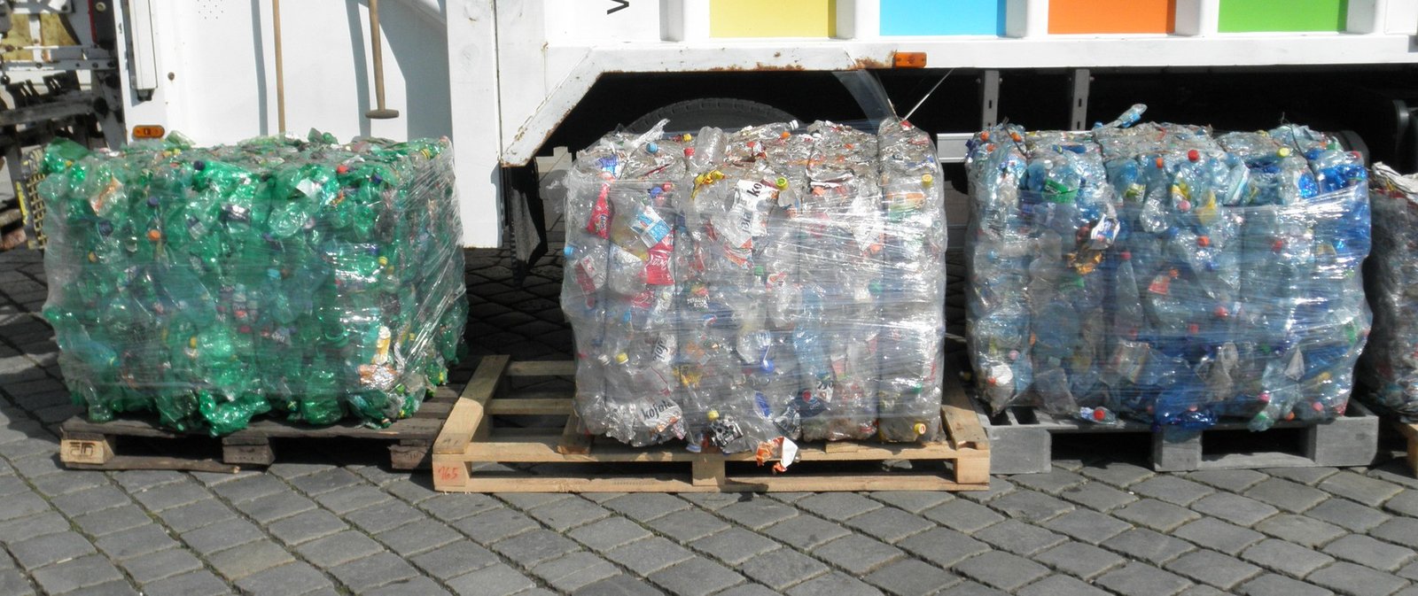 Wide landscape view of compacted PET plastic bottle bales ready for recycling