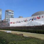 Rows of national flags flying outside the United Nations Headquarters in New York City