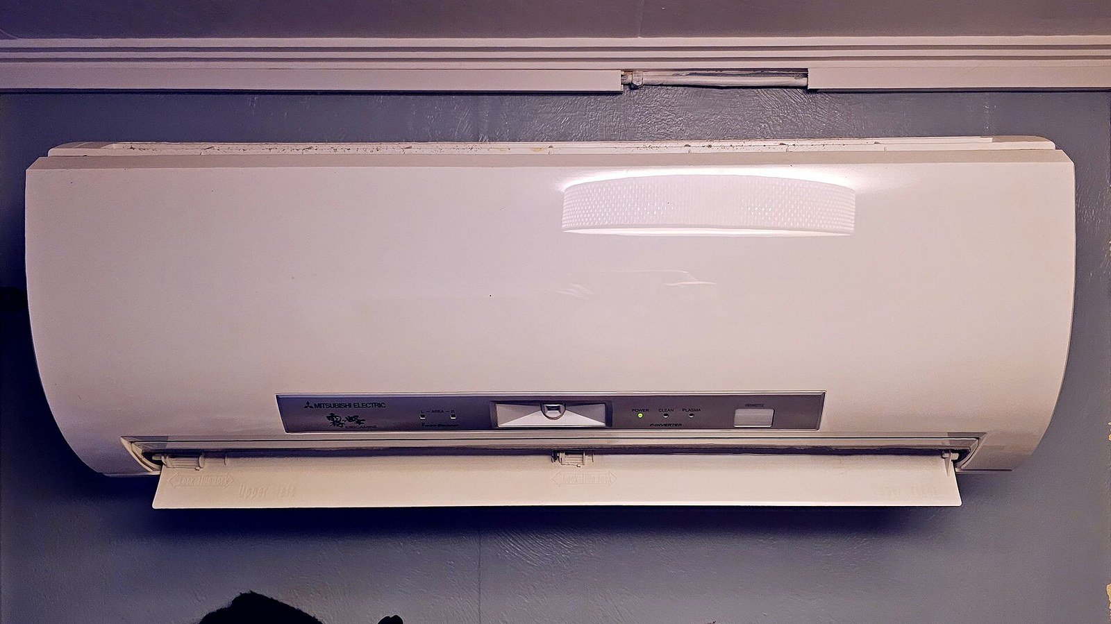 A heat pump unit mounted on the wall of a private house