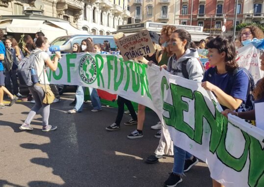 Young climate activists march with a Fridays for Future banner in Milan, Italy