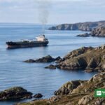 Oil tanker at sea near the rocky coast of Oman after a projectile strike
