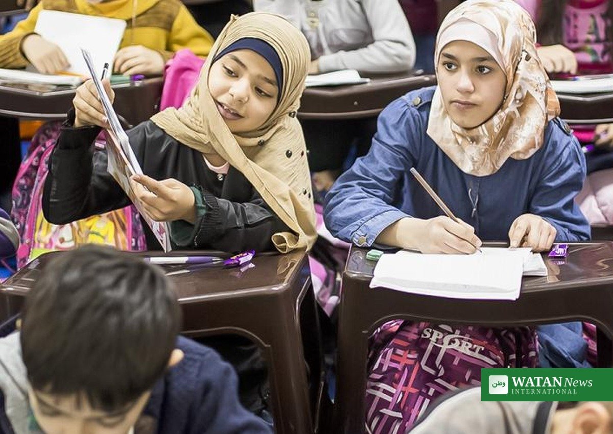Refugee schoolgirls studying at classroom desks, UNHCR report on refugee children education