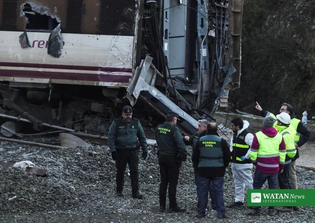 Investigators and Guardia Civil officers examine wrecked Renfe carriages at the Spanish rail crash site