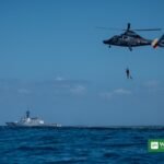 California smuggling boat rescue — U.S. Coast Guard cutter and search-and-rescue helicopter at sea