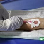 Kenya second Ebola death: health worker in full protective equipment takes a blood sample