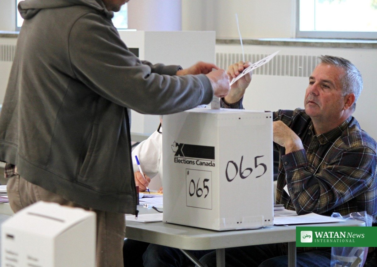 Alberta referendum: a voter casts a ballot in a Canadian polling station