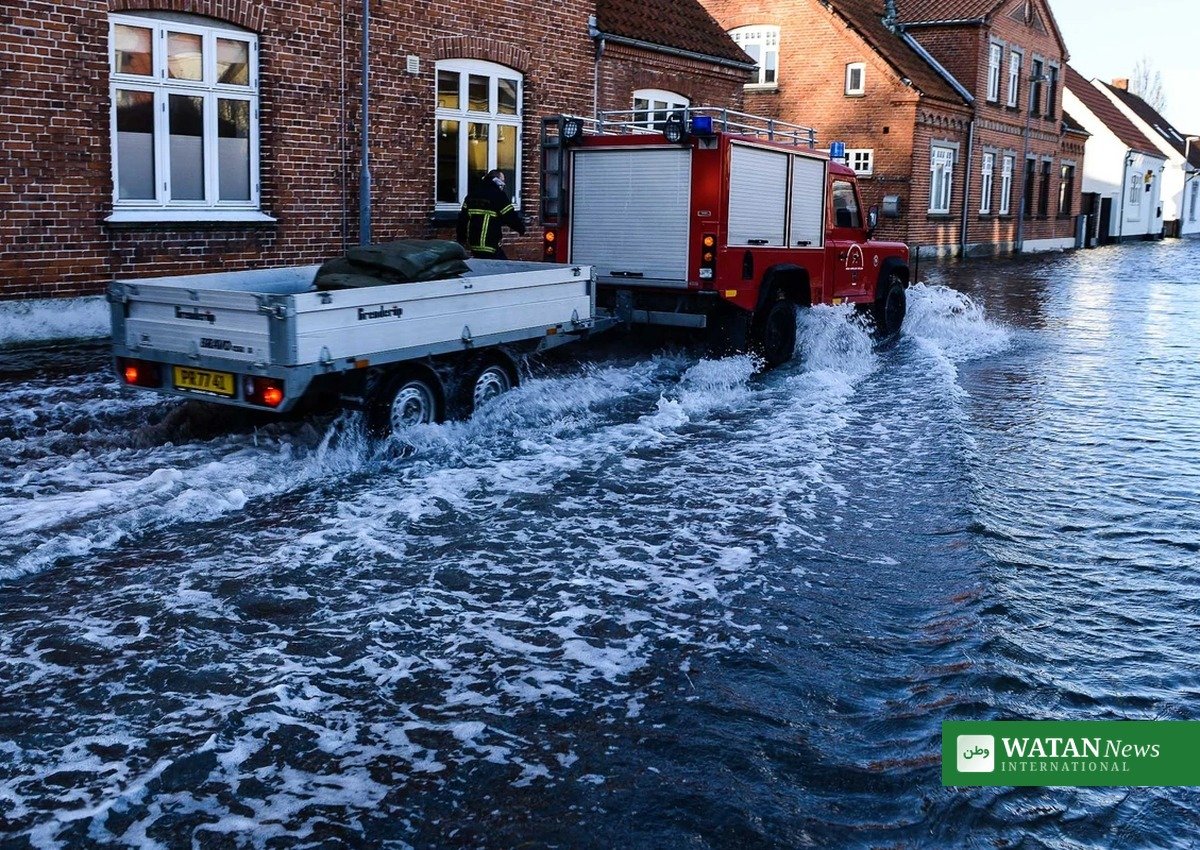 Oversvømmet dansk villavej med brandvæsen under oversvømmelse – klimaforandringer i Danmark oplevet i lokalområdet
