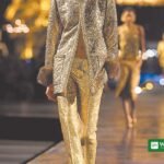 پیرس فیشن ویک میں سینٹ لوراں کے سونے کے بروکیڈ سوٹ میں ماڈل
