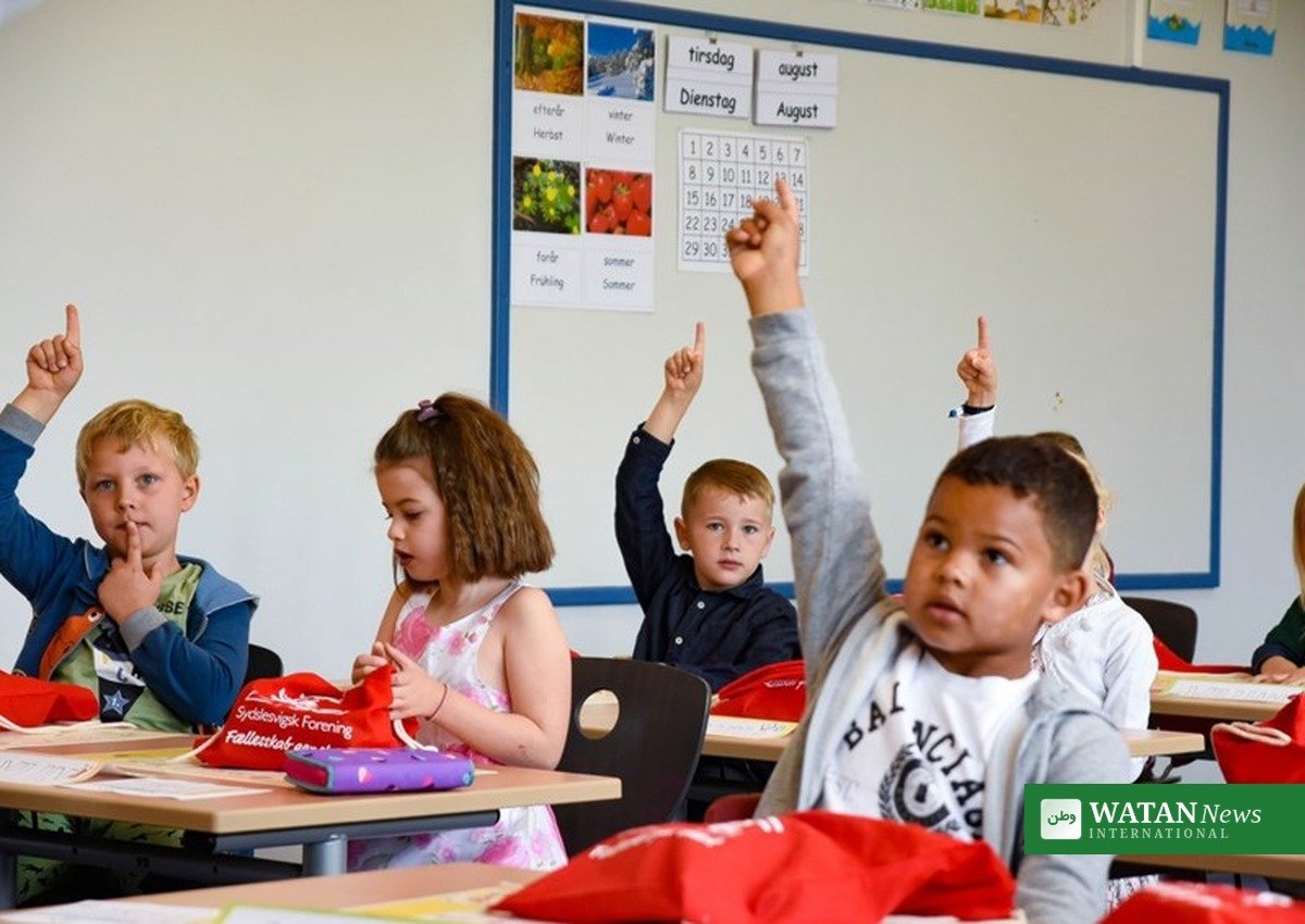 Young pupils raising hands in a Danish primary school class affected by the Danish schools violence report