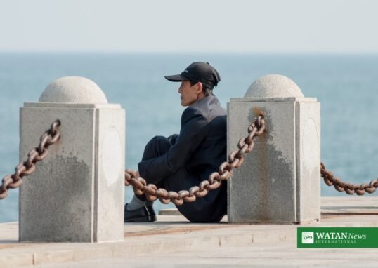 Elderly man sitting by the sea in Dalian, China