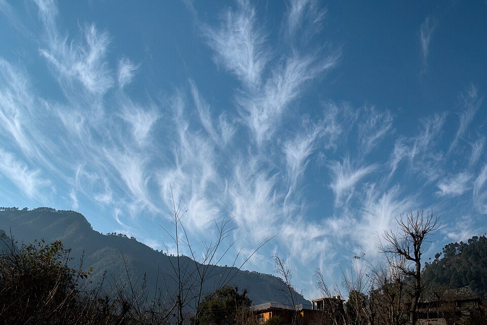Cirrus clouds in the Earth atmosphere above a mountain landscape