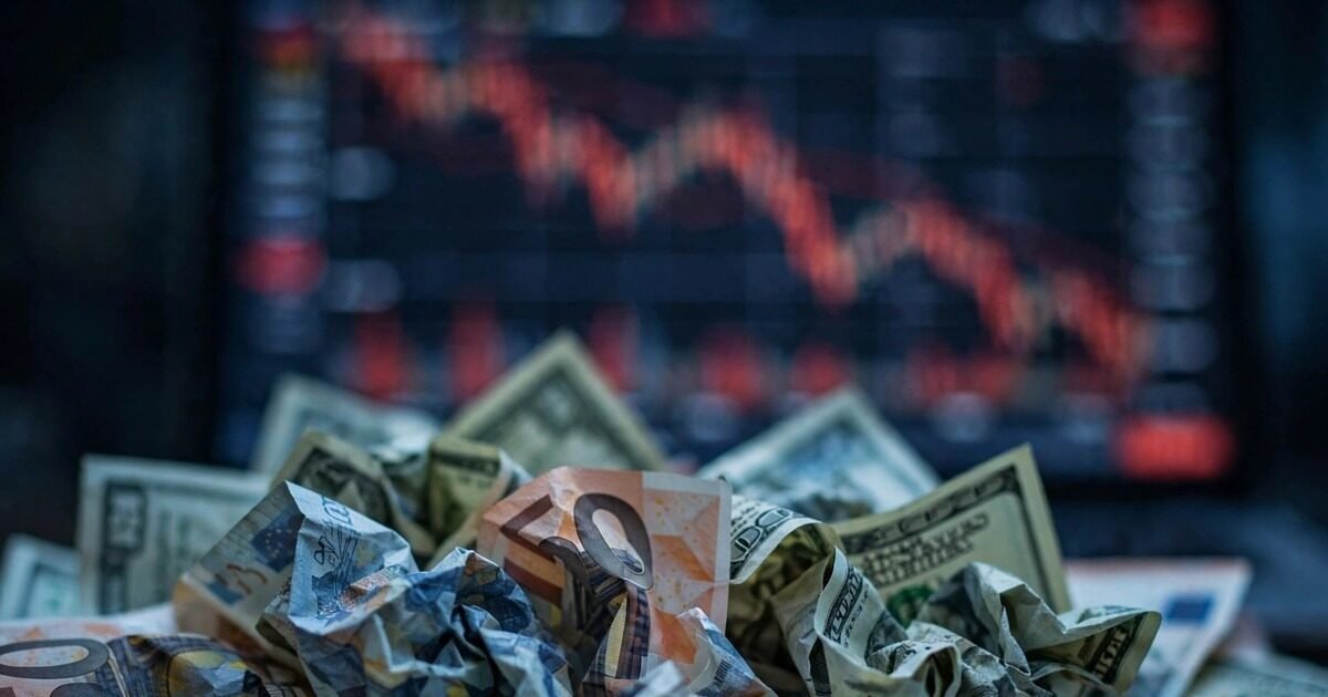 Euro hits 17-month low against the US dollar: euro and dollar banknotes in front of a falling market chart