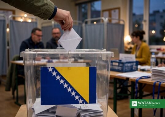 A voter casts a ballot into a box carrying the Bosnian flag as polls close in the Bosnia-Herzegovina election