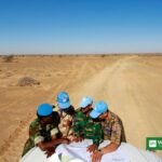 UN MINURSO peacekeepers in blue caps studying a map in the Western Sahara desert