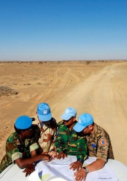 UN MINURSO peacekeepers in blue caps studying a map in the Western Sahara desert