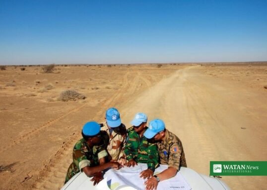 UN MINURSO peacekeepers in blue caps studying a map in the Western Sahara desert