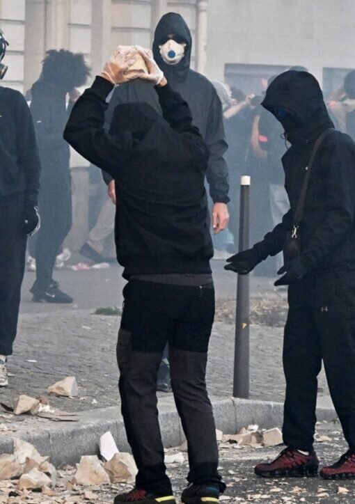 Masked demonstrators with stones amid tear gas during the Paris cost-of-living protest on 31 October 2026