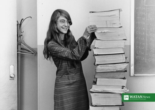 Margaret Hamilton in 1969 standing beside the printed Apollo guidance software code