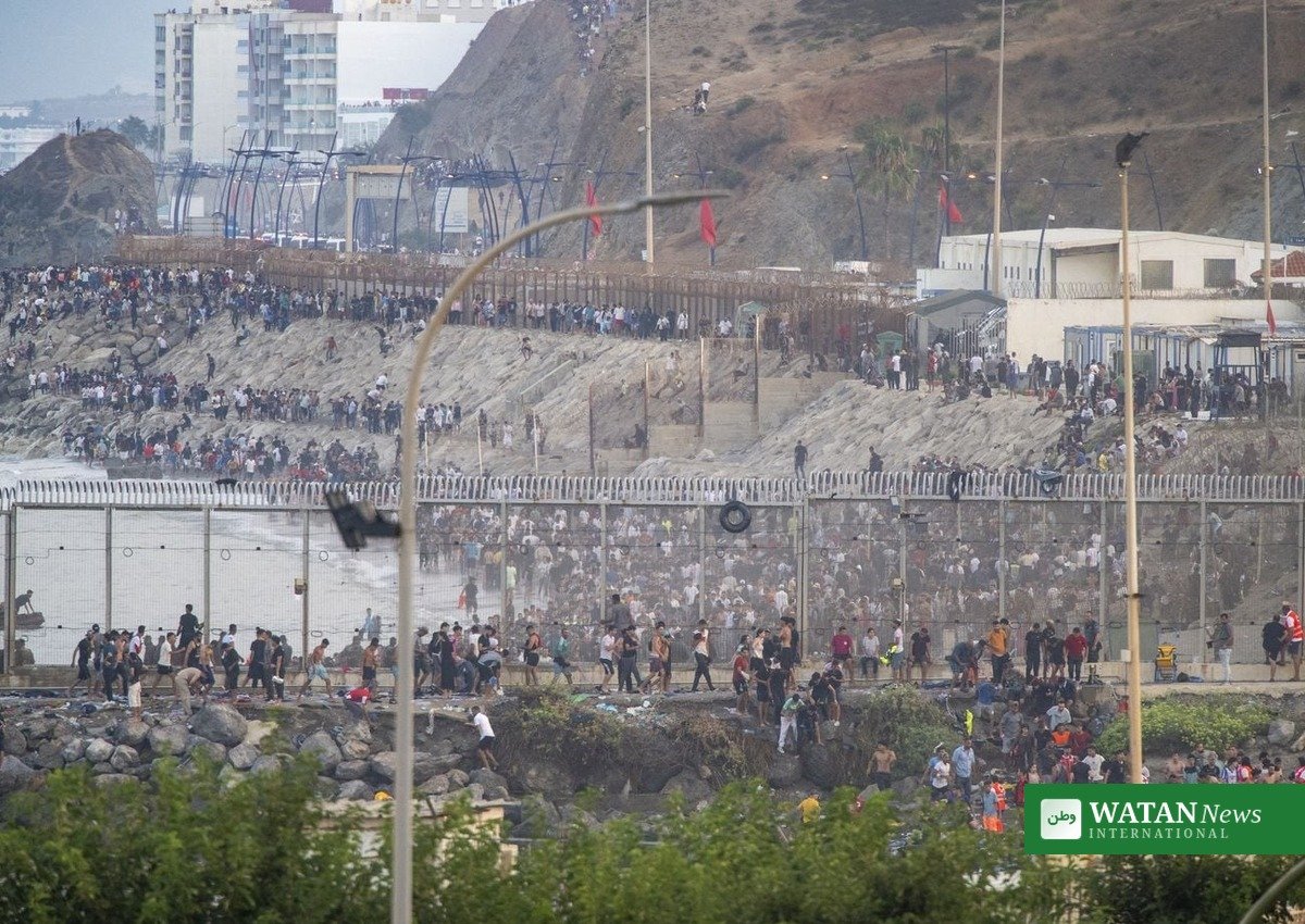 Migrants gather at the Ceuta border fence during the July 2026 mass crossing
