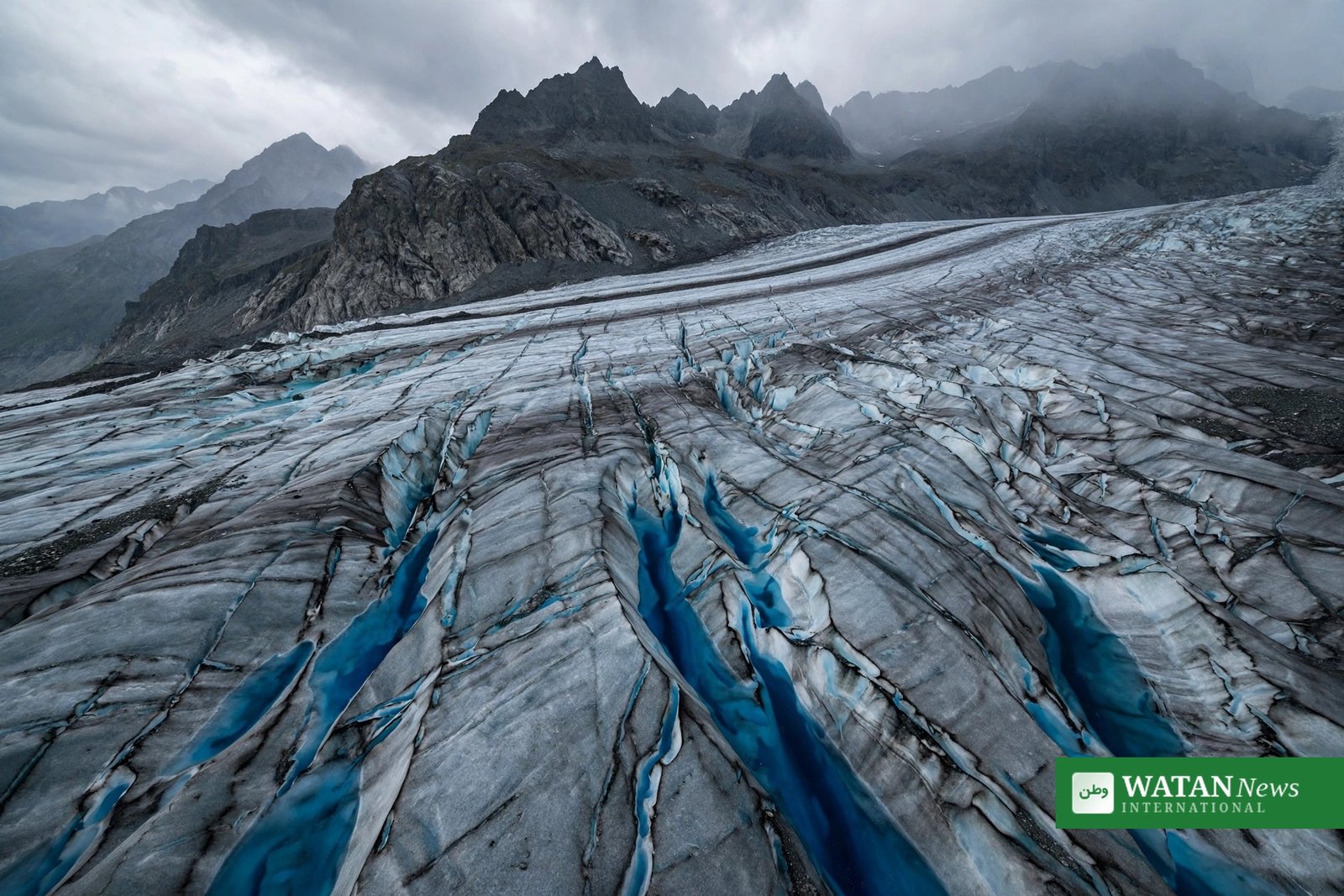 Swiss glaciers ice loss 2026 – blue meltwater channels cutting through a Swiss Alpine glacier