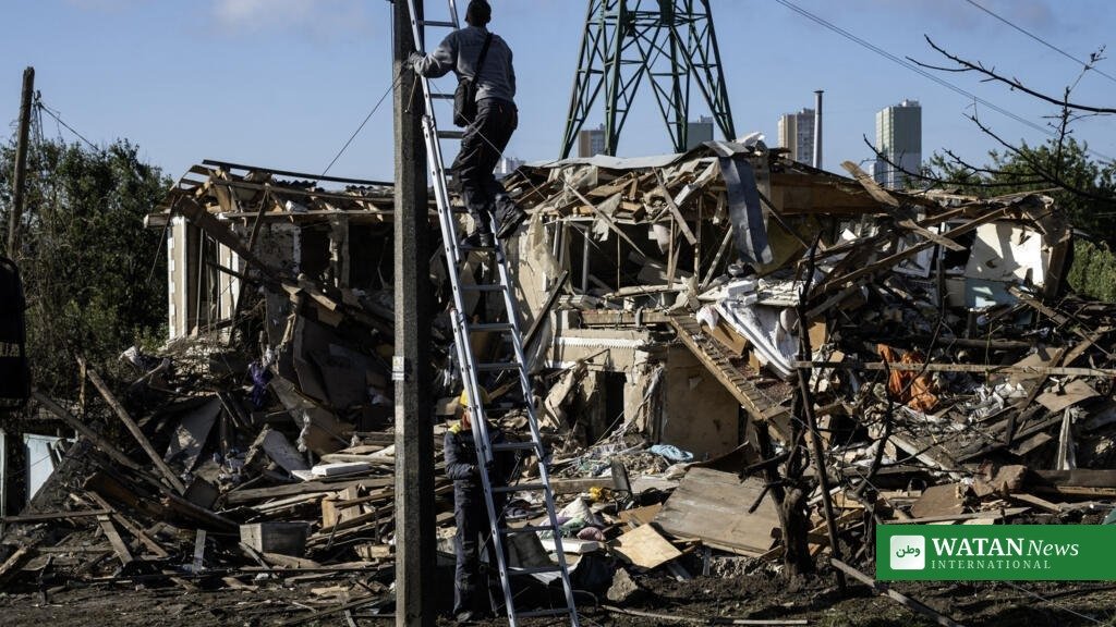 Ukraine energy grid attack: rescue worker climbs a ladder amid rubble after Russian strikes