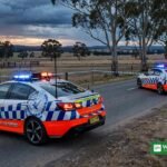 NSW police shooting scene: highway patrol cars with flashing lights at a rural road near Yass