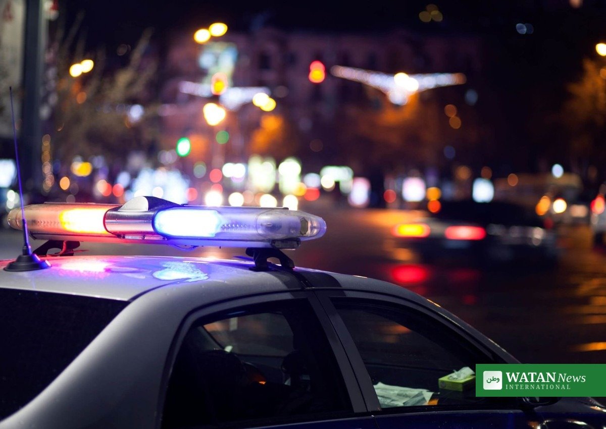 Police car with flashing lights at night during a shooting investigation