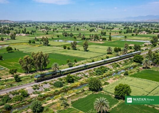 سبز کھیتوں کے درمیان پٹری پر چلتی مسافر ٹرین